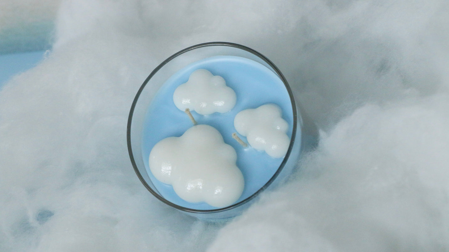 Cloud-shaped candles in a glass bowl on a snowy background