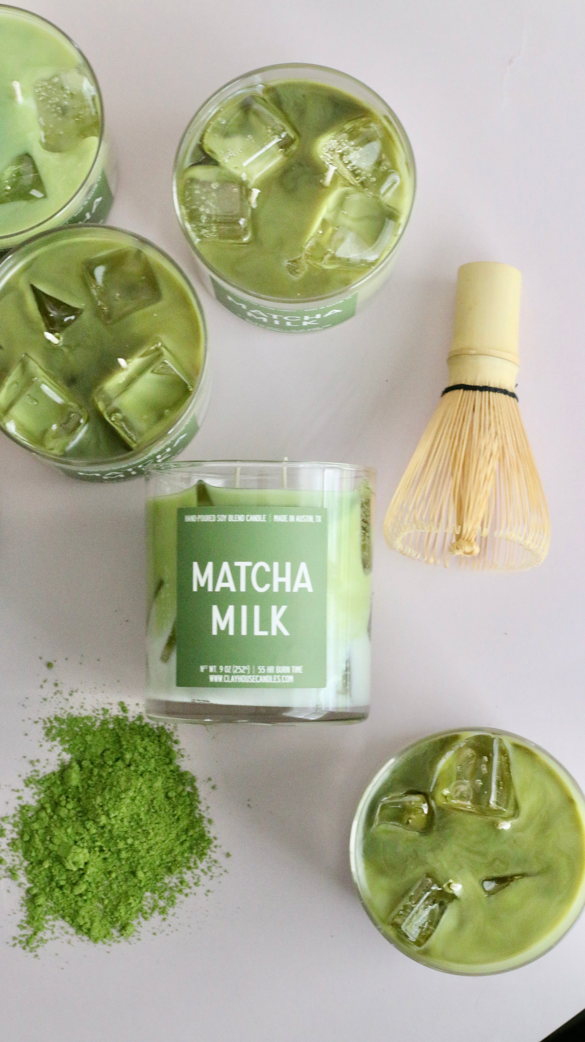 Matcha milk packaging with matcha powder and glasses of matcha milk on a white background