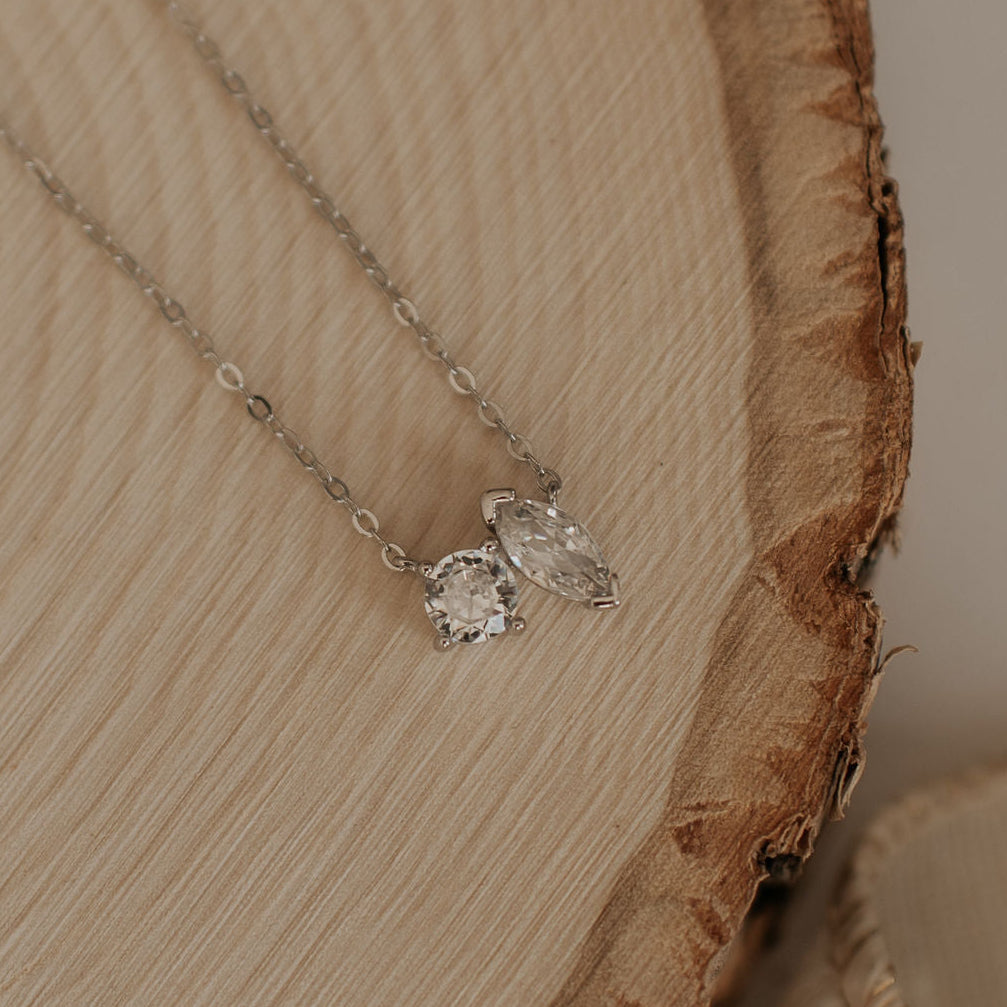 Necklace with two diamond pendants on a wooden surface