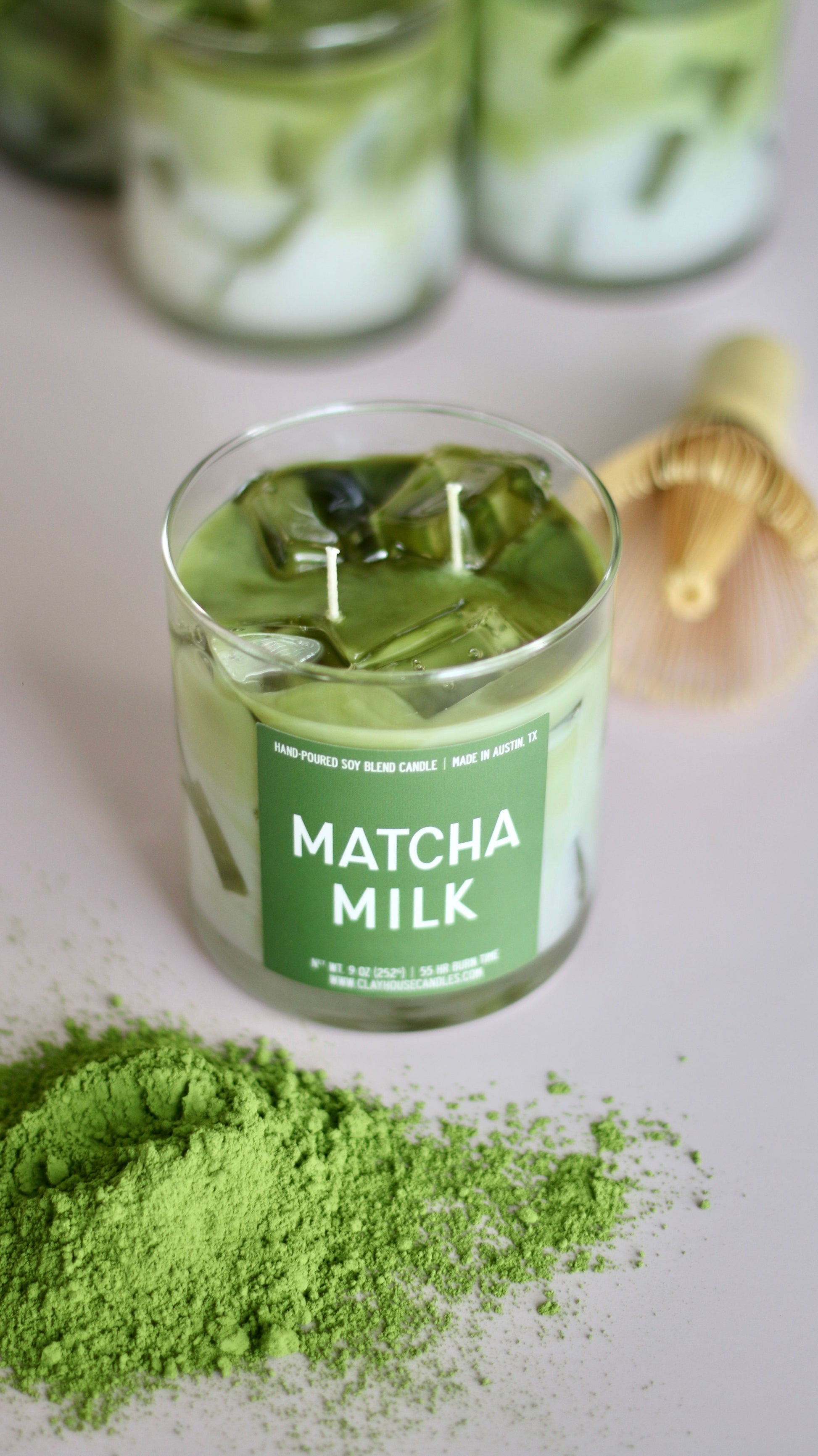Matcha milk jar with green label on a light surface with matcha powder.