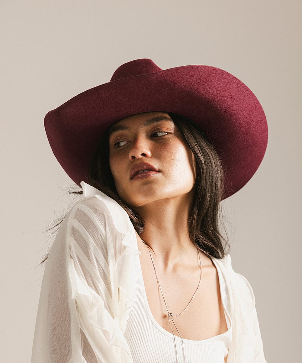 Woman wearing a burgundy hat against a neutral background